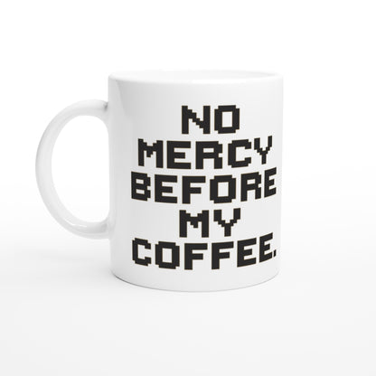 Taza friki No Mercy Before My Coffee 325 ml vista lateral, rostro pixelado con expresión intensa y tipografía retro de estilo videojuego.