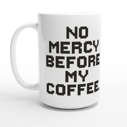 Taza friki No Mercy Before My Coffee 440 ml colocada en escritorio gamer, diseño retro para fans del pixel art y el café matutino.